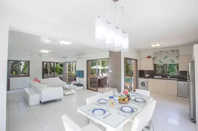 a kitchen and living room with a table and chairs at Protaras Demetra Villa DE1 in Protaras