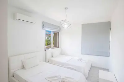 a white room with two beds and a window at Protaras Demetra Villa DE1 in Protaras