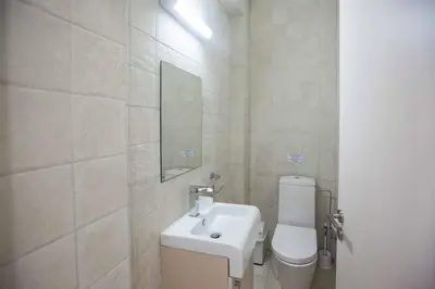 a white bathroom with a toilet and a sink at Protaras Demetra Villa DE1 in Protaras