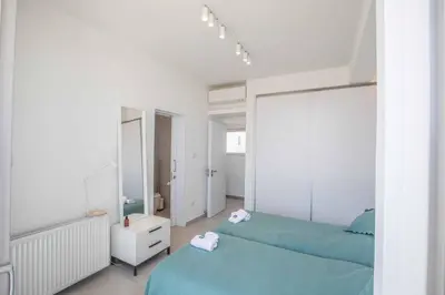 a white bedroom with two beds and a mirror at Olivine Pearl OL3 in Protaras