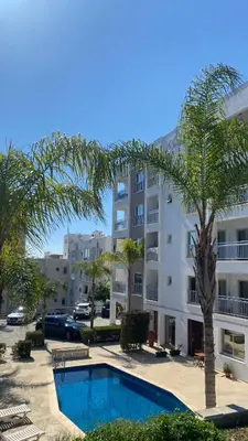 a hotel with a swimming pool in front of a building at T&L Apartments Agiaos Tychonas in Limassol