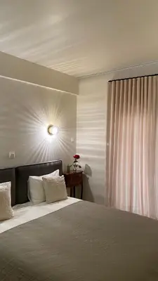 a bedroom with a large bed and a window at T&L Apartments Agiaos Tychonas in Limassol