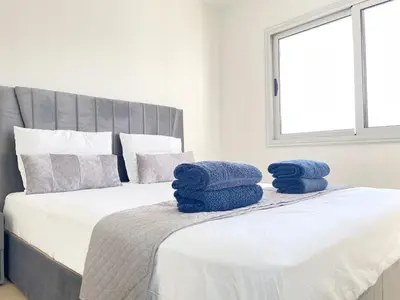 two blue towels sitting on top of a bed at Sunset Pearl Holiday Apt. - Ayia Napa in Ayia Napa