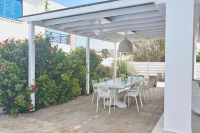 a patio with a table and chairs under a pergola at Serifos Villa 7 - 100 meters from Malama Beach in Protaras