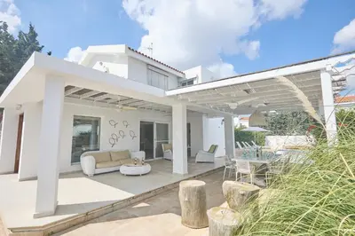a white house with a patio with a couch and chairs at Serifos Villa 7 - 100 meters from Malama Beach in Protaras