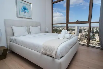 a white bed in a room with large windows at 360 Nicosia Heights, Gym & Pool in Nicosia