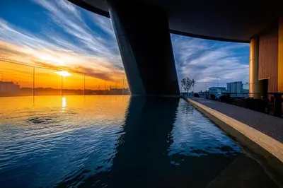 a swimming pool with a sunset in the background at 360 Nicosia Heights, Gym & Pool in Nicosia