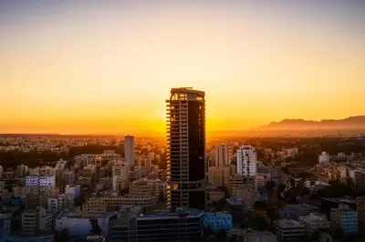a tall building in a city at sunset at 360 Nicosia Heights, Gym & Pool in Nicosia