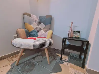 a chair sitting in a corner with a side table at STAY Kallipoleos Apartment in Nicosia
