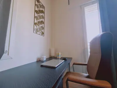 a laptop computer sitting on a desk with a chair at STAY Kallipoleos Apartment in Nicosia