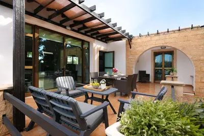 an outdoor patio with chairs and a table at Villa Anthia - 2bed with Large Pool in Ayia Napa