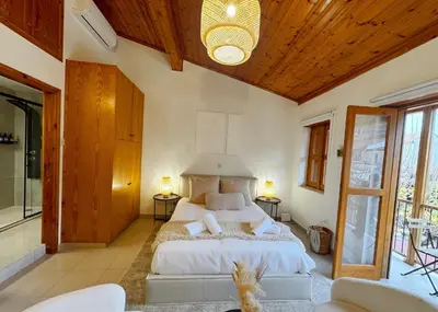 a bedroom with a large bed with a wooden ceiling at Maison Damianou Elegant Loft in Omodos