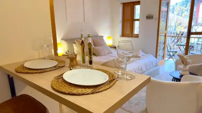 a table with two plates and wine glasses on it at Maison Damianou Elegant Loft in Omodos