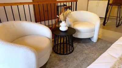 two chairs and a table with a vase of flowers at Maison Damianou Elegant Loft in Omodos