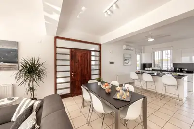 a living room with a couch and a table at Faros Seaside Villa Larnaca in Pervolia