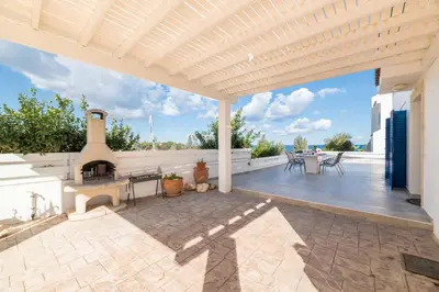 an outdoor patio with a fireplace and a table at Villa Malamar in Protaras