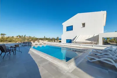 a villa with a swimming pool and lounge chairs at Villa Malamar in Protaras