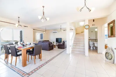 a dining room and living room with a table and chairs at Villa Malamar in Protaras