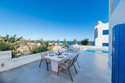a patio with a table and chairs and a pool at Villa Malamar in Protaras