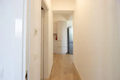 a kitchen with white walls and a hallway with a refrigerator at Flat in Nicosia's centre in Nicosia