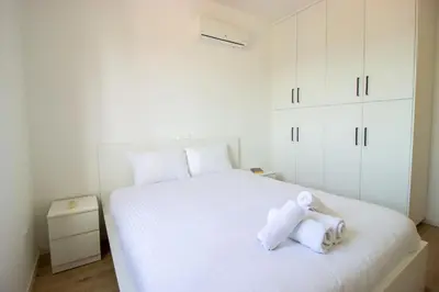 a white bed with a teddy bear sitting on it at Flat in Nicosia's centre in Nicosia