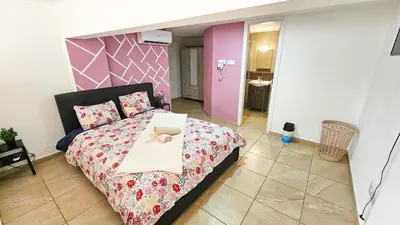 a bedroom with a bed with a pink head board at Duplex Apartment in Larnaka