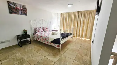 a bedroom with a bed and a table and a window at Duplex Apartment in Larnaka