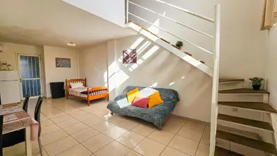 a living room with a couch and a staircase at Duplex Apartment in Larnaka
