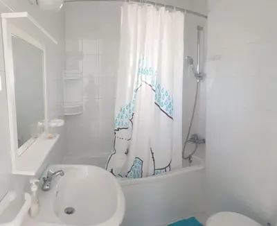 a bathroom with a sink and a toilet and a shower curtain at Sea Heart Villa Beachfront in Pyla