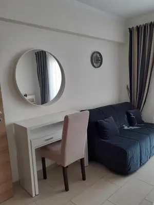a living room with a blue couch and a mirror at Luxury Cozy Apartment near NISSI BEACH in Ayia Napa