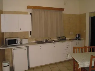 a kitchen with white cabinets and a sink and a microwave at Eligonia Hotel Apartments in Ayia Napa