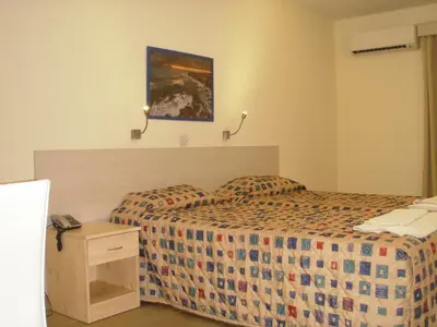 a hotel room with two beds and a night stand at Eligonia Hotel Apartments in Ayia Napa