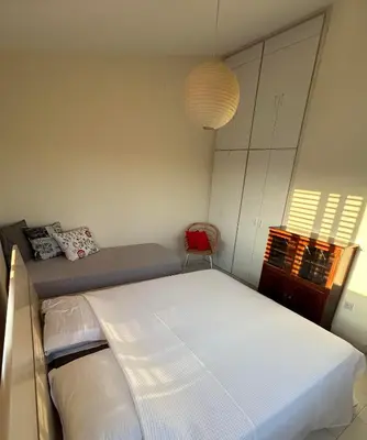 a bedroom with a bed and a red chair at Beautiful maisonette in Protaras in Protaras