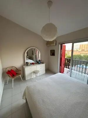 a bedroom with a bed and a mirror and a chair at Beautiful maisonette in Protaras in Protaras