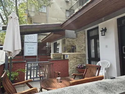 a patio with chairs and a table and an umbrella at Maryland Lodge kakopetria in Kakopetria