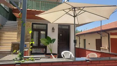 a house with an umbrella and two chairs at Maryland Lodge kakopetria in Kakopetria