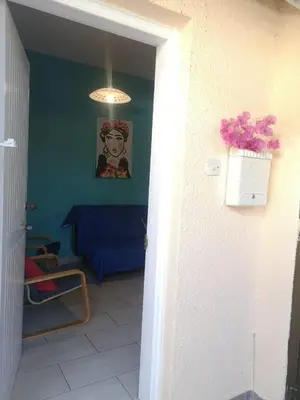 a living room with a blue couch and a table at Miranda Beach House in Voroklini