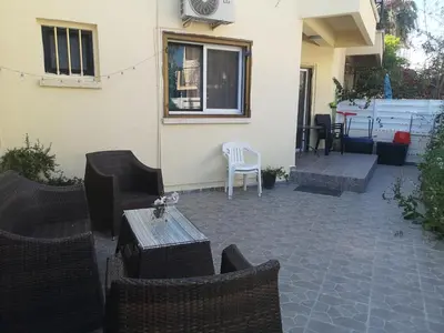 a patio with chairs and a table and a window at Miranda Beach House in Voroklini