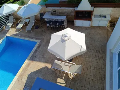an overhead view of an umbrella and chairs next to a pool at Horizon Villa Protaras in Protaras