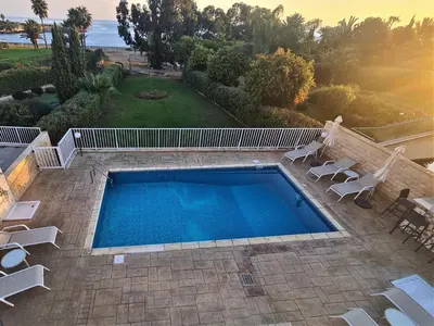 a swimming pool with white chairs and a swimming pool at Horizon Villa Protaras in Protaras