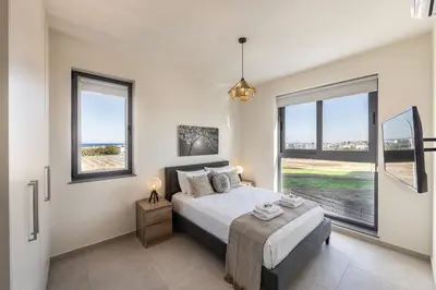 a bedroom with a bed and two windows at Protaras Hestia Seaside Villa B6 in Protaras