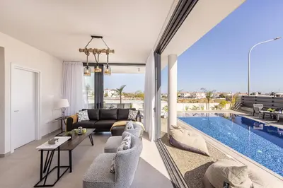 a living room with a couch and a swimming pool at Protaras Hestia Seaside Villa B6 in Protaras
