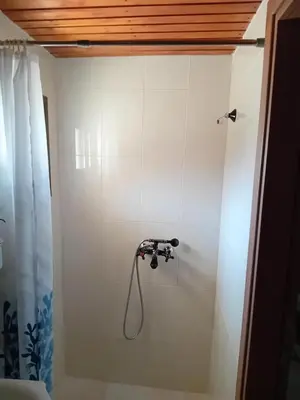 a shower with a hose in a white wall at TRADITIONAL HOUSE ARSOS in Arsos