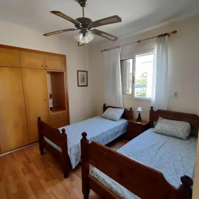 a bedroom with two beds and a ceiling fan at Quiet holiday house near the beach in Meneou