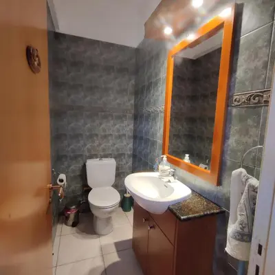 a bathroom with a toilet and a sink and a mirror at Quiet holiday house near the beach in Meneou