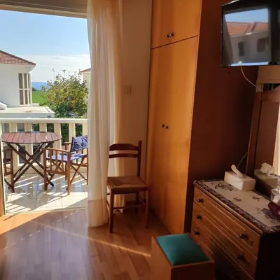 a room with a balcony with a table and chairs at Quiet holiday house near the beach in Meneou