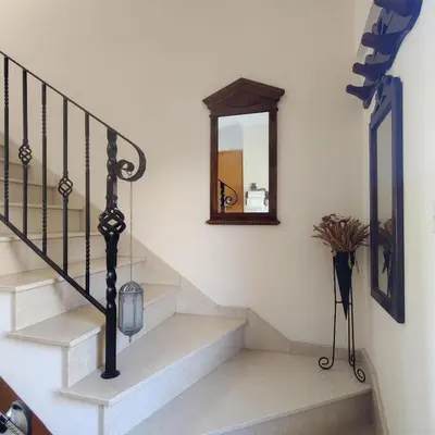 a staircase with a mirror on the wall and a vase at Quiet holiday house near the beach in Meneou