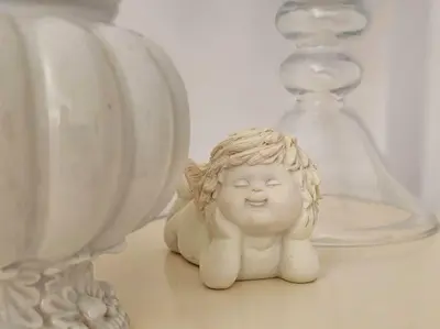 a small angel figurine sitting on a table next to glassases at Nissi beach villa Holiday in Ayia Napa