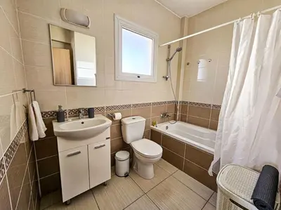 a bathroom with a toilet and a sink and a tub at Nissi beach villa Holiday in Ayia Napa