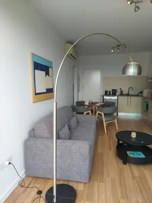 a living room with a couch and a floor lamp at Milepost vacations in Paralimni